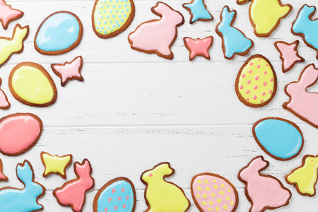 Easter gingerbread cookies on wooden table. Rabbits and eggs. Greeting card. Top view with space for...
