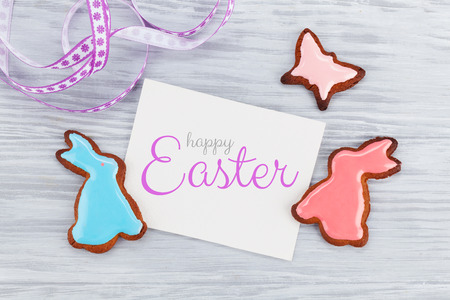 Easter greeting card with colorful gingerbread cookies. Top view on wooden table with space for your greetingsの写真素材
