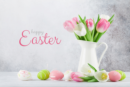 Easter greeting card with tulip flowers and easter eggs. In front of stone wallの写真素材