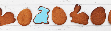 Easter greeting card with gingerbread cookies. Top view on wooden table with space for your...