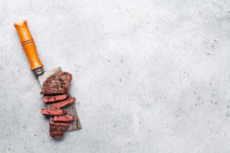 Top blade or denver grilled steak over meat butcher knife. Top view with copy spaceの写真素材