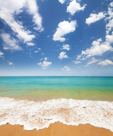 Summer sand beach, tropical sea waves and blue sky with clouds. Perfect vacation place landscapeの写真素材
