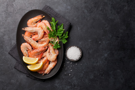 Steamed tiger shrimps with parsley and lemon. Top view with copy space for your textの写真素材