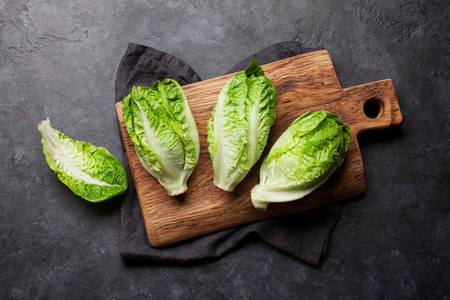 Mini romaine lettuce salad on stone kitchen table. Top view