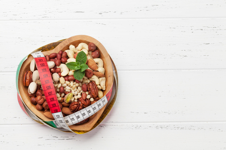 Various nuts selection: peanuts, hazelnuts, chestnuts, walnuts, pistachio and pecans on wooden table. Top view with space for your textの写真素材
