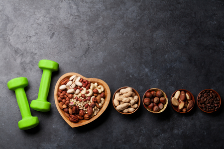 Healthy food and fitness concept. Nuts and dumbbels. Top view flat lay with copy space for your textの写真素材