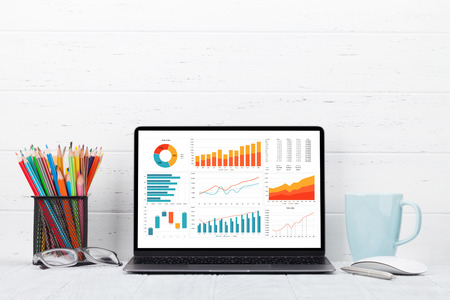 Loft home office workplace with blank white screen laptop computer, coffee cup and accessories. With copy space for your mockup or textの写真素材