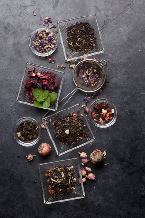 Set of different herbal and fruit dry teas in bowls on stone table. Top view flat lay with copy spaceの写真素材