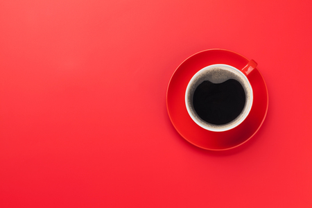 Red coffee cup over red background. Top view flat lay with copy spaceの写真素材