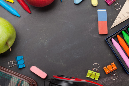 School education supplies on chalkboard backdrop. Back to school template concept. Top view flat lay...