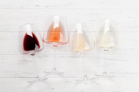 Various wine glasses on wooden table. Red, rose and white wines. Top view flat lay with copy space for your textの写真素材