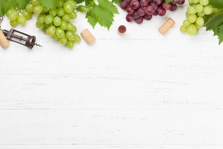 Various grapes, wine corks and corkscrew on wooden table. Top view flat lay with copy space for your textの写真素材
