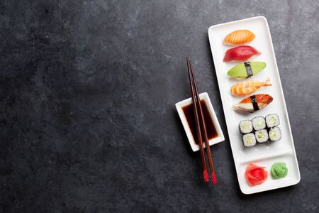 Japanese sushi set. Sashimi, maki rolls. On plate over stone background. Top view flat lay with copy space for your textの写真素材