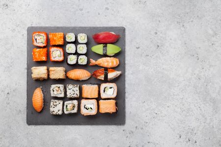Japanese sushi set. Sashimi, maki rolls. On plate over stone background. Top view flat lay with copy space for your textの写真素材