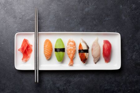 Japanese sushi set. Sashimi, maki rolls. On plate over dark stone background with space for your textの写真素材