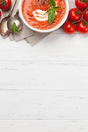 Cold gazpacho soup with ripe tomatoes, cucumber and basil on wooden table. Top view flat lay with copy space for your textの写真素材