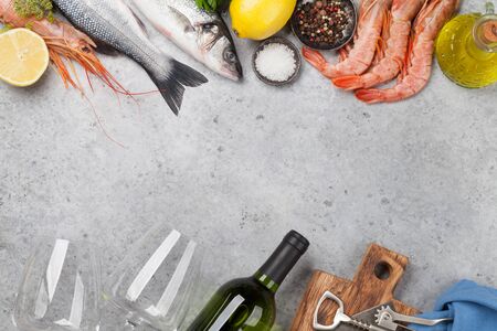 Fresh seafood. Trout fish and langostino shrimps with herbs and spices on a stone background. Top view flat lay. With copy space for your textの写真素材
