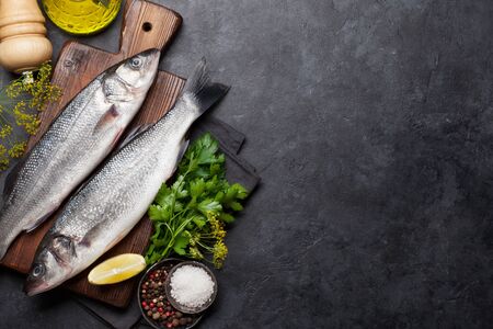 Fresh seafood. Trout fish with herbs and spices on a stone background. Top view flat lay. With copy space for your textの写真素材