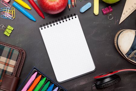 School education supplies on chalkboard backdrop. Back to school template concept. Top view flat lay...