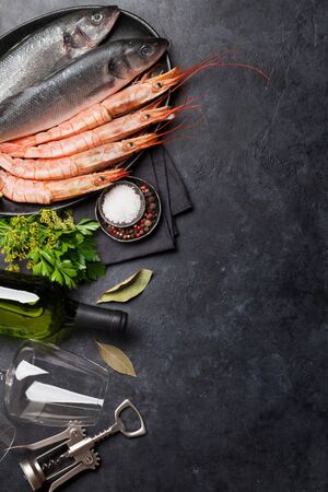 Fresh seafood. Trout fish and langostino shrimps with herbs and spices on a stone background. Top view flat lay. With copy space for your textの写真素材