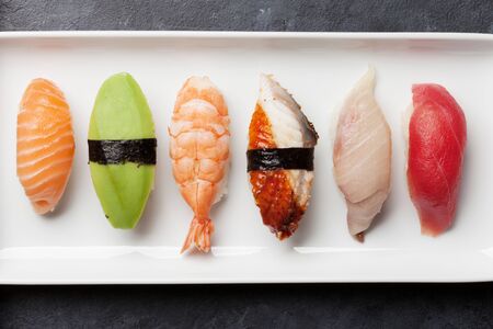 Japanese sushi set. Sashimi, maki rolls. On plate over stone background. Top view flat layの写真素材
