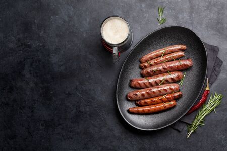 Grilled sausages with rosemary herbs and glass of dark beer. Top view with copy spaceの写真素材