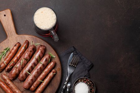 Grilled sausages with rosemary herbs and glass of dark beer. Top view with copy spaceの写真素材