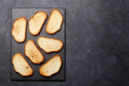 Toast bread slices on stone table. Top view with copy space