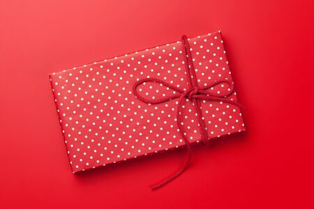 Christmas or Valentine's day gift box on red background. Top view. Flat layの写真素材