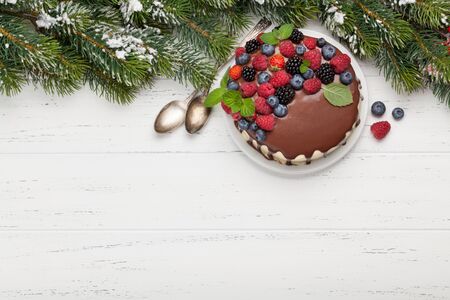 Christmas holiday chocolate cheesecake with berries. On wooden table with copy space. Top view flat layの写真素材