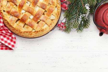 Christmas holiday greeting card with apple pie and fir tree. On wooden table with copy space. Top view flat layの写真素材