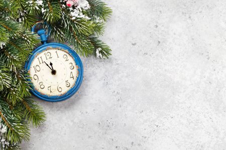 Fir tree and alarm clock over stone texture background. Top view with copy space for your greetings