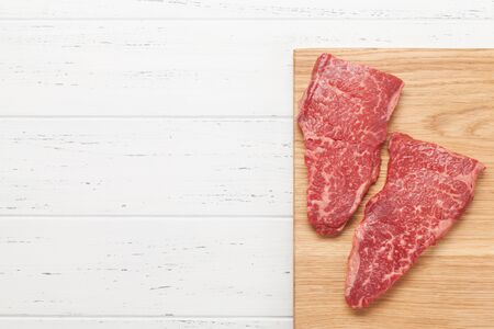 Raw marbled beef steak on wooden board. Top view flat lay with copy spaceの写真素材