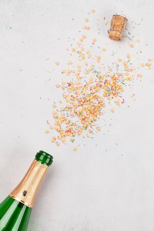 Champagne bottle and sweets holiday template. Christmas, Birthday or Valentines'day backdrop. Top view with space for your greetingsの写真素材