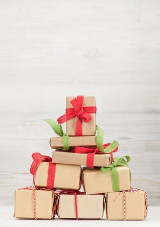 Christmas greeting card with various gift boxes in front of wooden wall with copy space for your greetingsの写真素材