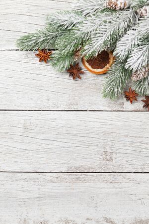 Christmas greeting card with fir tree and spices over white wooden background and copy space for your xmas greetings. Top view flat layの写真素材