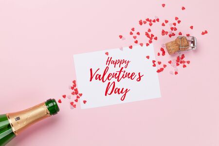 Champagne and heart shaped sweets holiday template. Valentines'day over pink background. Top view with space for your greetings. Flat layの写真素材