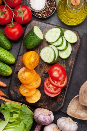 Assorted raw organic vegetables, herbs and spices. Fresh garden vegetarian food cooking. Top view on stone tableの写真素材