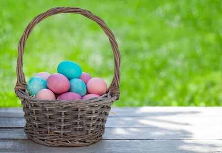 Easter eggs basket in a green grass garden. With copy space for your greetings