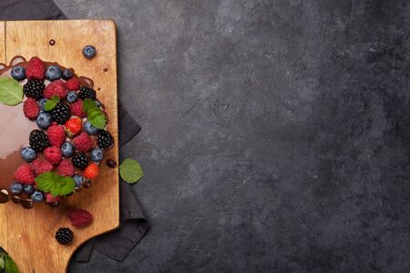 Chocolate cake or cheesecake with berries. On stone table with copy space. Top view flat layの写真素材