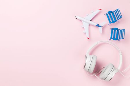 Travel concept with airplane, headphones and beach chairs. Top view flat lay with copy spaceの写真素材