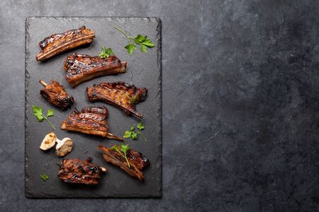Barbecue beef ribs with bbq sauce sliced on a stone board.の写真素材
