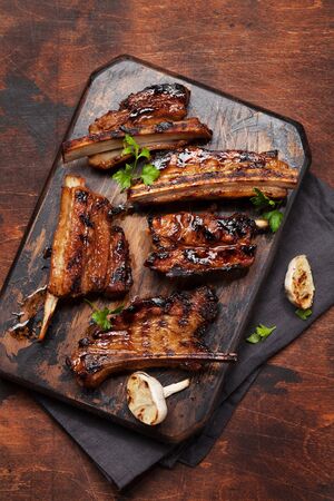 Barbecue beef ribs with bbq sauce sliced on a wooden board. Top view flat layの写真素材