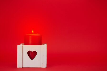 Valentines day greeting card with burning candle over red background with copy space for your greetingsの写真素材