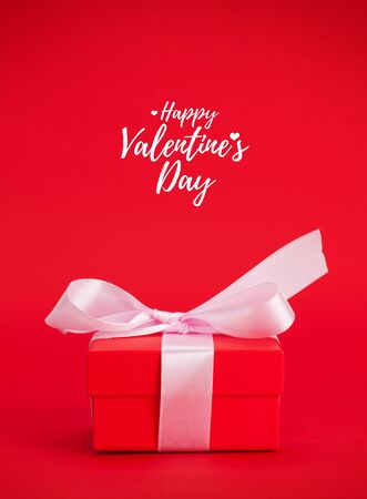 Valentines day gift box over red background with greetingsの写真素材