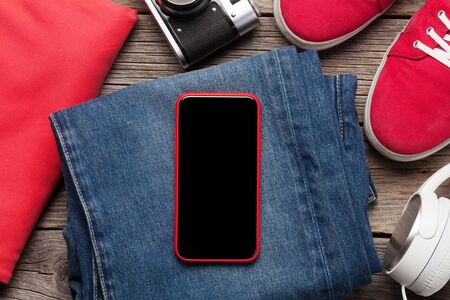 Clothing and accessories. Sneakers, jeans, headphones and smartphone. Urban outfit for everyday or...
