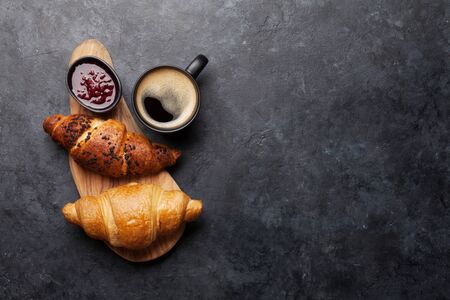 Breakfast with coffee, jam and croissant. Top view on stone table with copy space. Flat layの写真素材