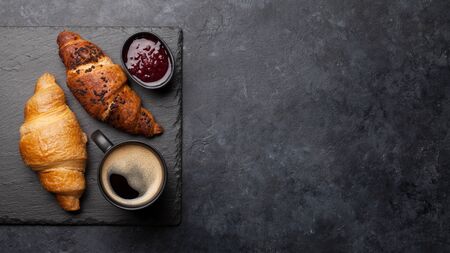 Breakfast with coffee, jam and croissant. Top view on stone table with copy space. Flat layの写真素材