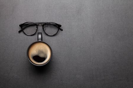 Office desk table with glasses and coffee. Dark workspace tabletop with copy space. Top view flat layの写真素材