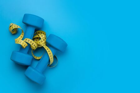 Fitness equipment on a blue background. Top view flat lay with copy space for workout planの写真素材